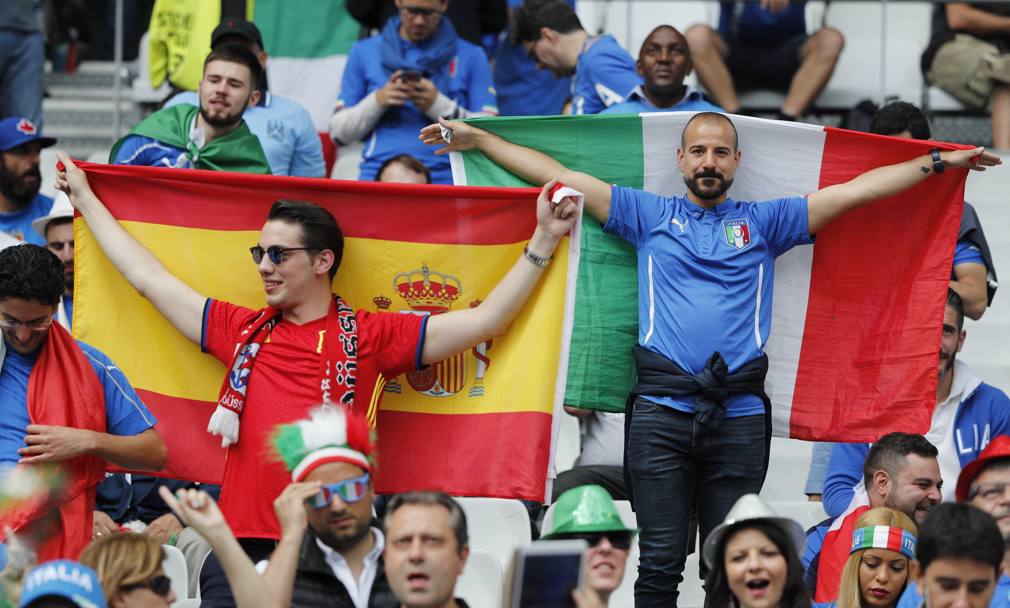 Due tifosi, uno azzurro, l&#39;altro spagnolo, con le rispettive bandiere. Lapresse